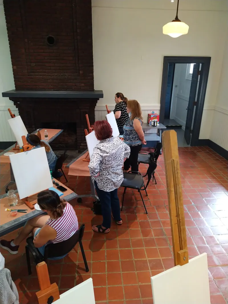 Artists at easels in a MAX salon, seen from above