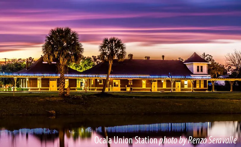 Union Station at sunset, reflected in water beneath palms